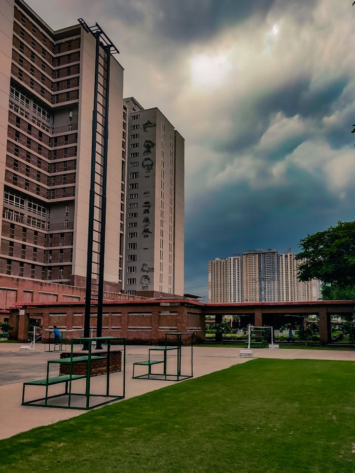 Exterior view of contemporary apartment buildings with a dramatic cloudy sky, enhancing the modern architectural design.